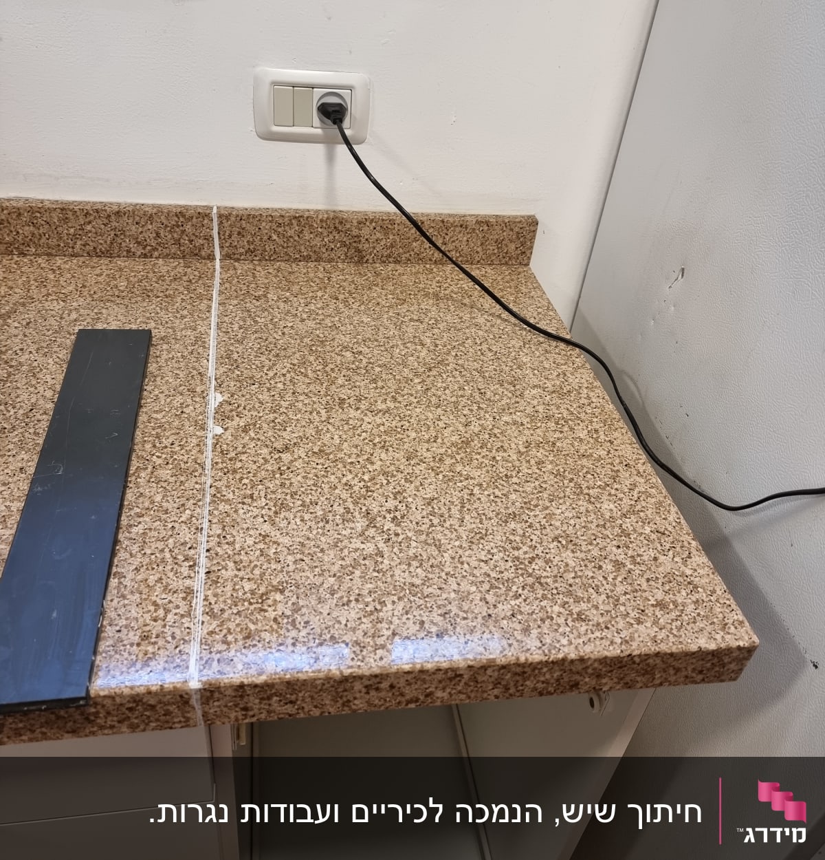 משטח שיש חום עם חיבור חשמלי על הקיר